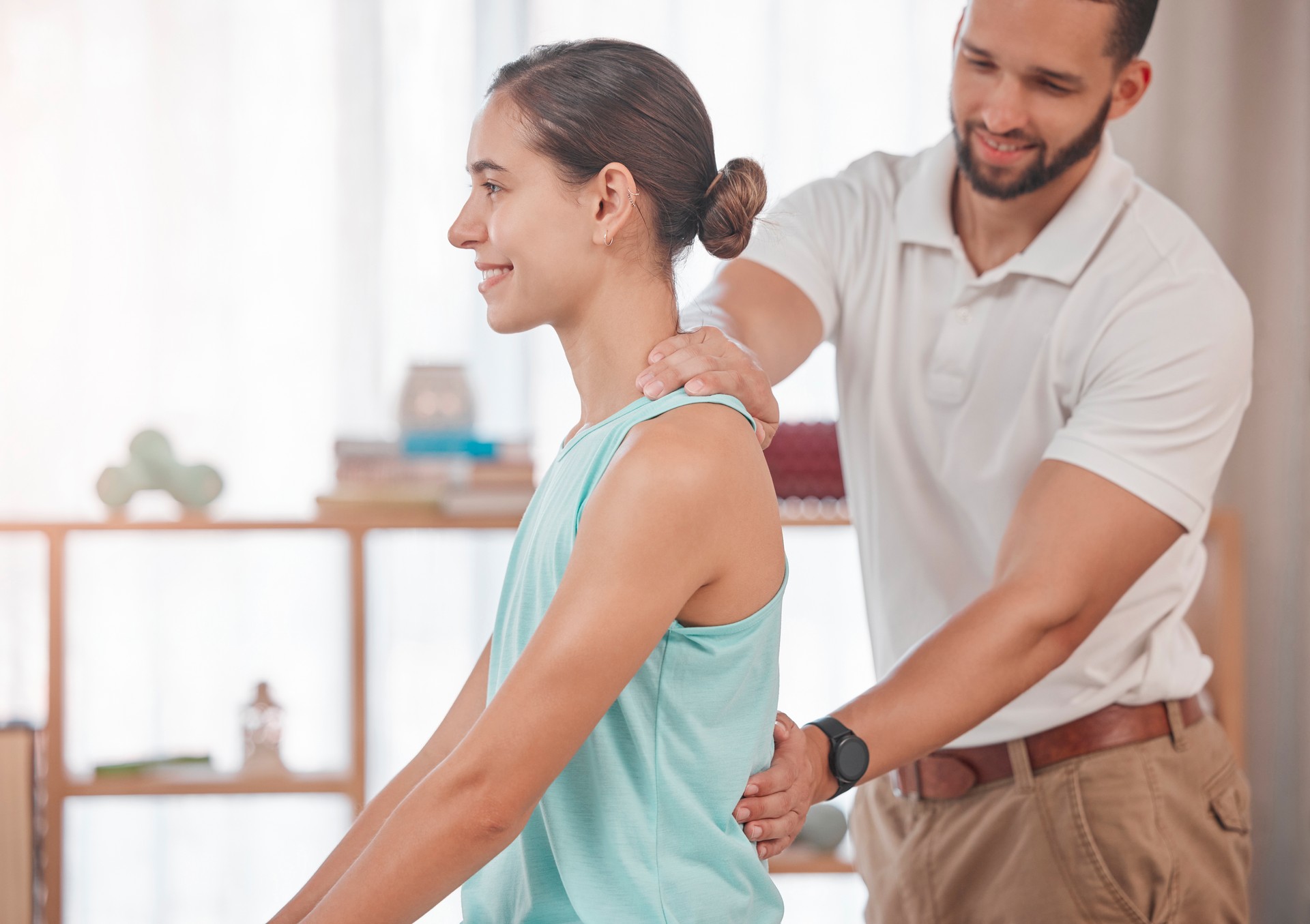 Physiotherapy, chiropractor and consulting with woman and doctor for healthcare, medical or sports therapy. Healing, wellness and training with spine of patient and man help for back injury exam